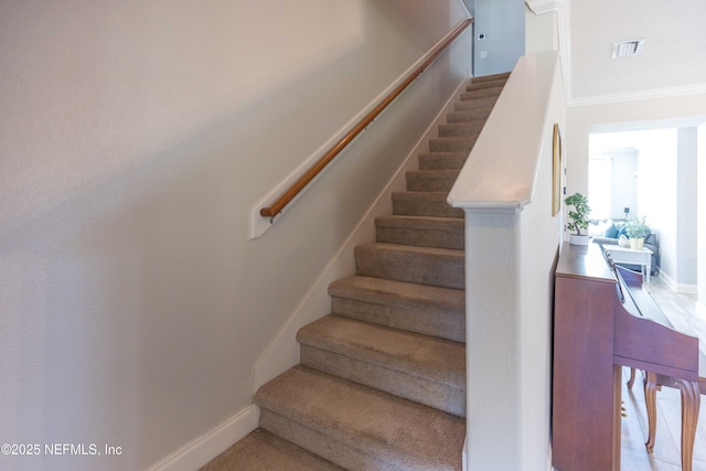 staircase featuring baseboards and visible vents