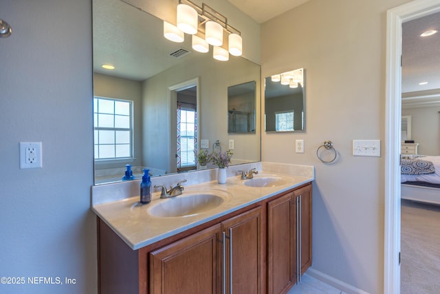 full bathroom featuring double vanity, visible vents, ensuite bathroom, and a sink