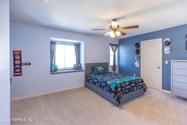 carpeted bedroom featuring a textured ceiling, baseboards, and a ceiling fan