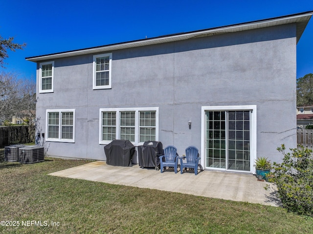 back of house with a patio area, a lawn, stucco siding, and fence