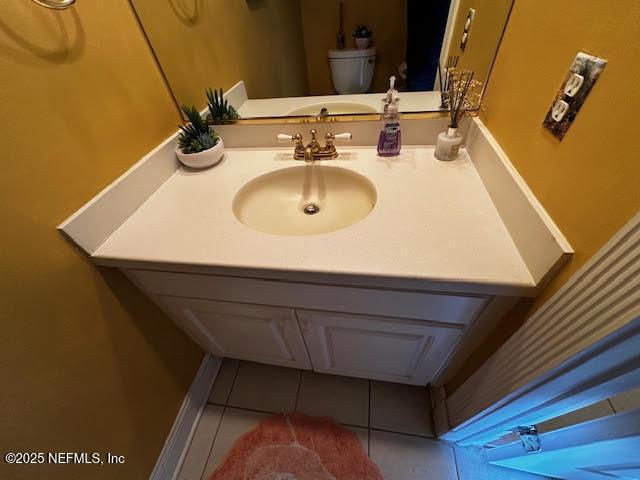 bathroom with vanity, toilet, and tile patterned flooring