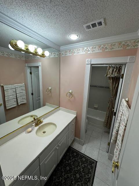 full bathroom featuring tile patterned flooring, visible vents, vanity, ornamental molding, and a textured ceiling