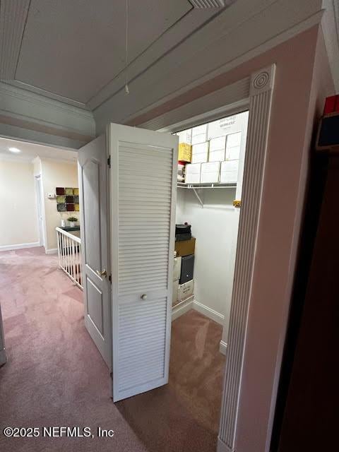 hallway with baseboards, carpet, and attic access