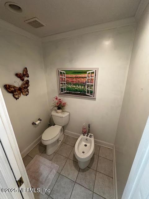 half bath featuring a bidet, visible vents, ornamental molding, tile patterned flooring, and toilet