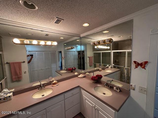 full bathroom featuring visible vents, a textured ceiling, and a sink