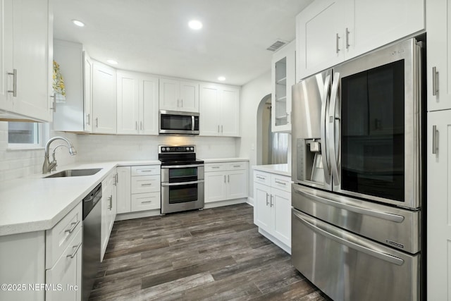 kitchen with dark wood-type flooring, white cabinets, visible vents, and appliances with stainless steel finishes