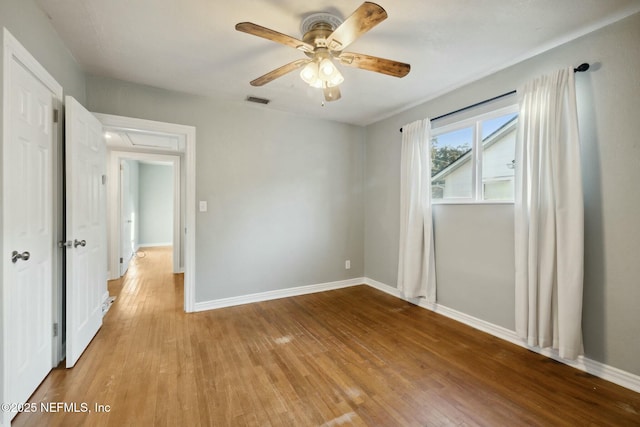 unfurnished bedroom with light wood-type flooring, visible vents, baseboards, and a ceiling fan