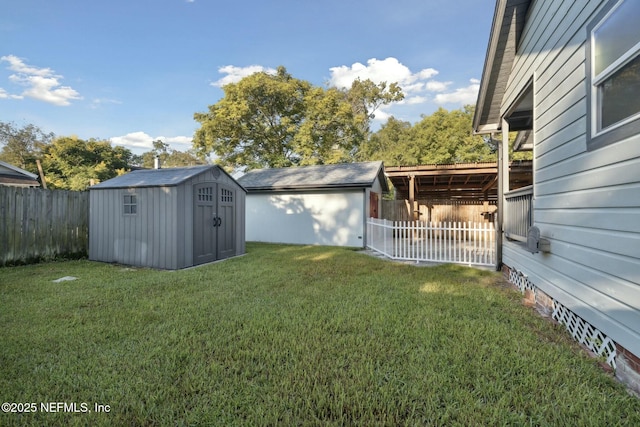 view of yard with an outbuilding, a storage unit, and a fenced backyard