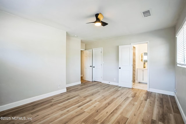 unfurnished bedroom with visible vents, light wood-style flooring, a ceiling fan, connected bathroom, and baseboards