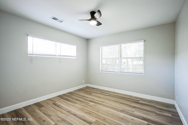 unfurnished room featuring visible vents, baseboards, a ceiling fan, and wood finished floors