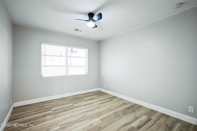 spare room with visible vents, baseboards, and wood finished floors