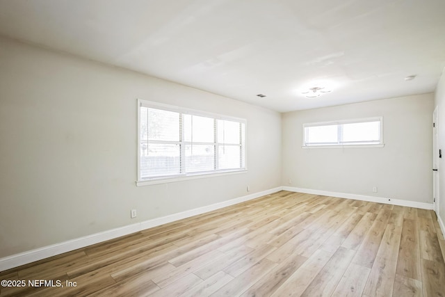 empty room with visible vents, baseboards, and light wood finished floors