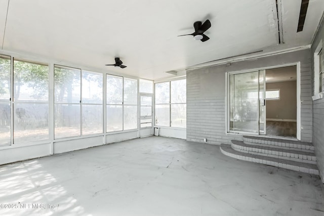 unfurnished sunroom with a ceiling fan