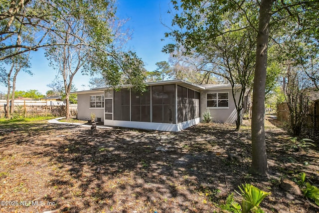 back of property featuring fence and a sunroom