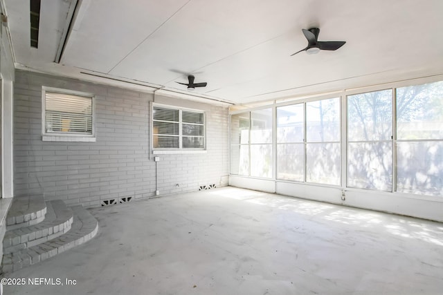 unfurnished sunroom with ceiling fan