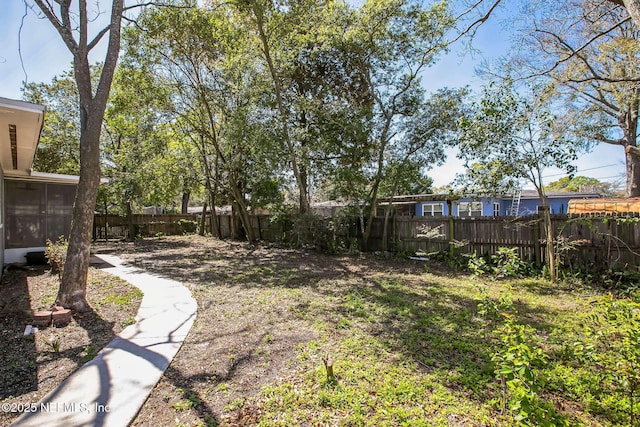 view of yard with a fenced backyard and a sunroom