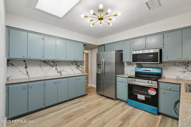 kitchen featuring visible vents, blue cabinetry, appliances with stainless steel finishes, and light wood-style floors