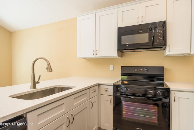 kitchen featuring black appliances, white cabinets, light stone countertops, and a sink