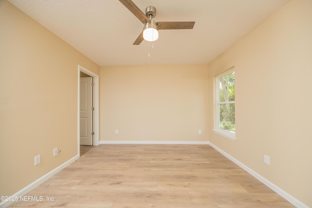 empty room with a ceiling fan, light wood-type flooring, and baseboards