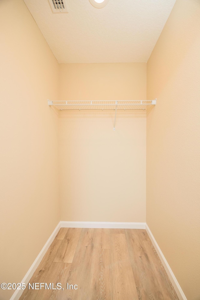 spacious closet featuring visible vents and light wood-style floors