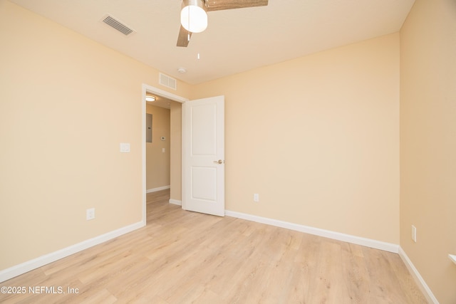 empty room with ceiling fan, light wood-style floors, visible vents, and baseboards