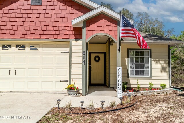 entrance to property with an attached garage and driveway