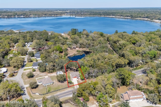 birds eye view of property featuring a wooded view and a water view