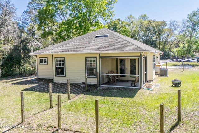 back of property featuring a lawn, french doors, roof with shingles, and fence