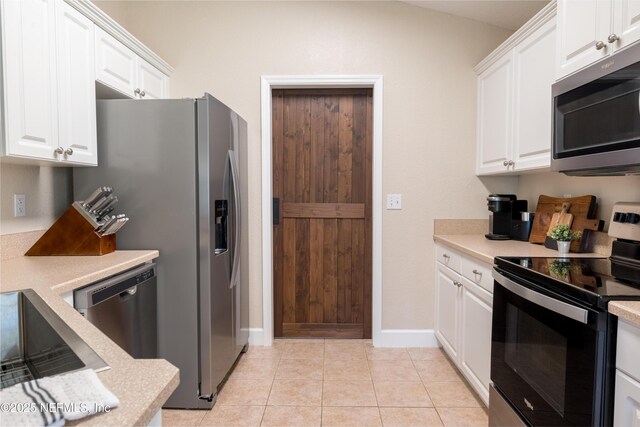 kitchen featuring white cabinetry, light countertops, light tile patterned flooring, and stainless steel appliances