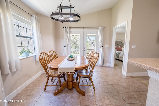 dining area with lofted ceiling, light tile patterned floors, french doors, and baseboards