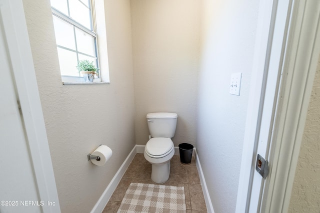 bathroom with tile patterned floors, baseboards, and toilet