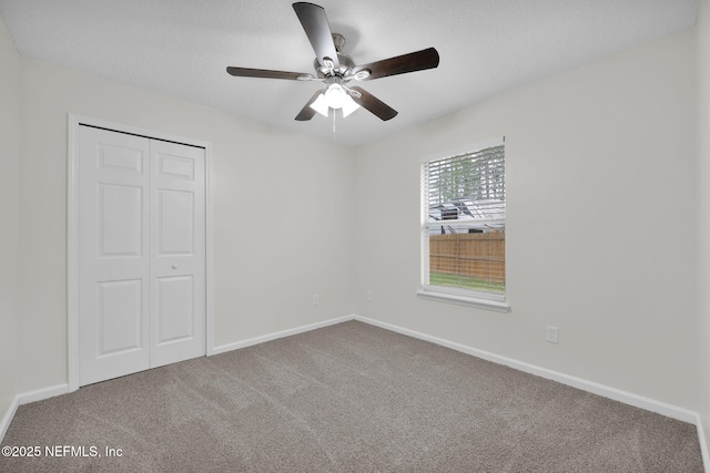 unfurnished bedroom with a closet, baseboards, carpet, and ceiling fan