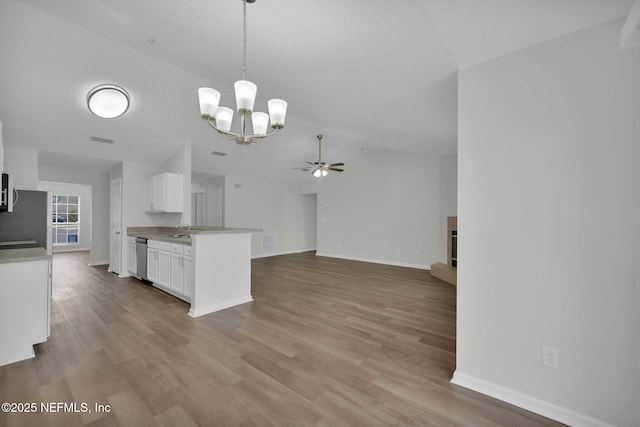 kitchen with light countertops, vaulted ceiling, appliances with stainless steel finishes, wood finished floors, and white cabinetry