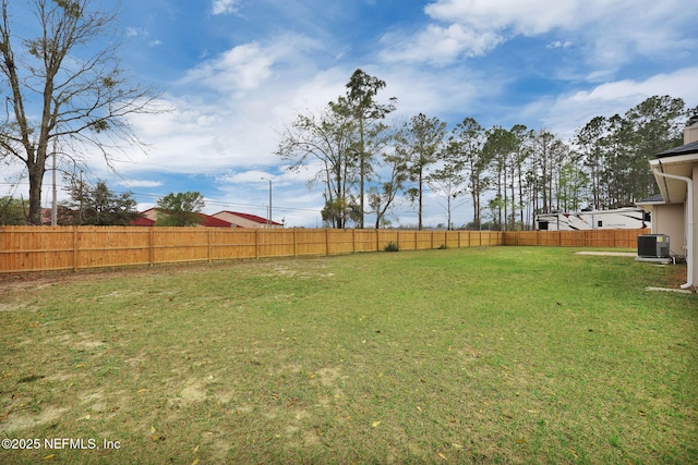 view of yard with central air condition unit and fence