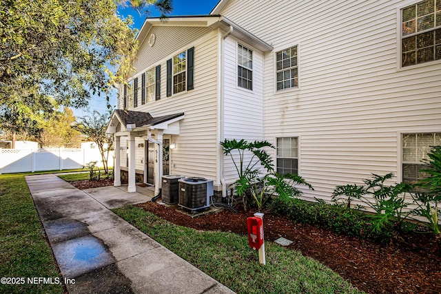 view of property exterior with fence and central AC