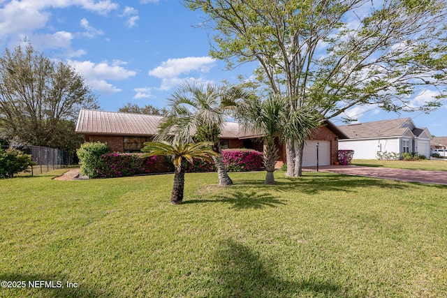 exterior space with a front lawn, fence, metal roof, a garage, and driveway