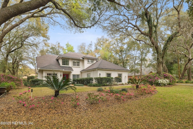 traditional home featuring a front lawn and stucco siding