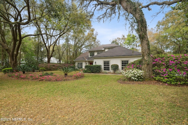 rear view of property with a yard and stucco siding