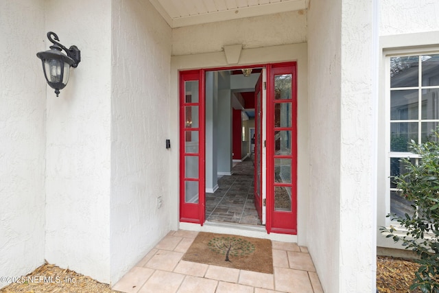 doorway to property featuring stucco siding