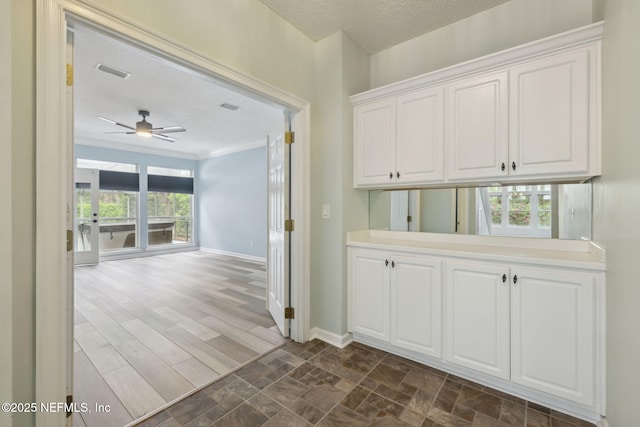 hall featuring dark wood finished floors, visible vents, a textured ceiling, and baseboards