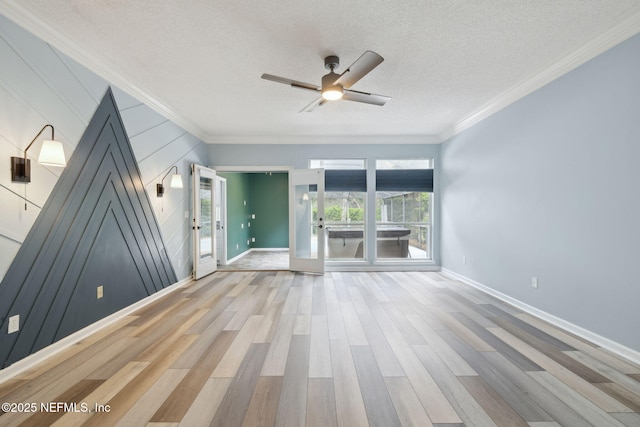 unfurnished living room featuring crown molding, wood finished floors, baseboards, and a textured ceiling