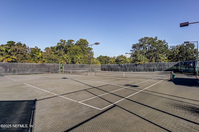 view of tennis court with fence