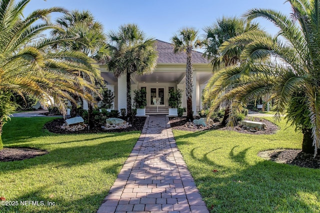 view of front facade with a front lawn, french doors, and roof with shingles