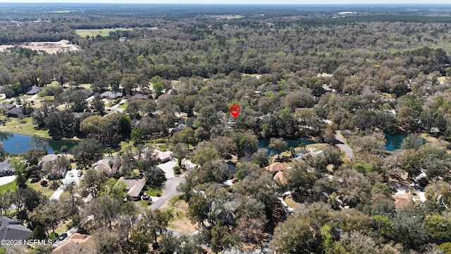 birds eye view of property featuring a forest view and a water view