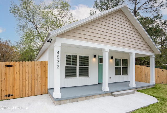 view of front facade featuring a porch and fence