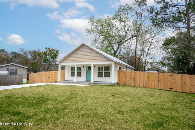 bungalow with covered porch, board and batten siding, a front yard, and fence