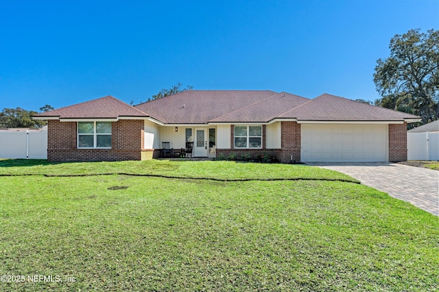 single story home with decorative driveway, fence, and brick siding