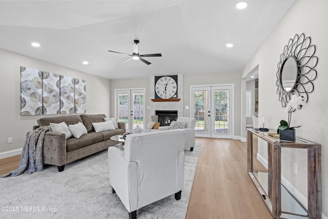 living room featuring light wood-style flooring, recessed lighting, french doors, and baseboards