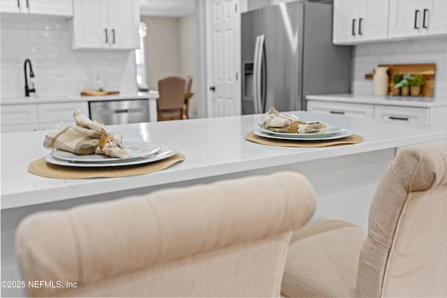 kitchen featuring white cabinetry, light countertops, tasteful backsplash, and appliances with stainless steel finishes