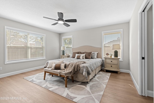 bedroom with baseboards, a textured ceiling, ceiling fan, and light wood finished floors